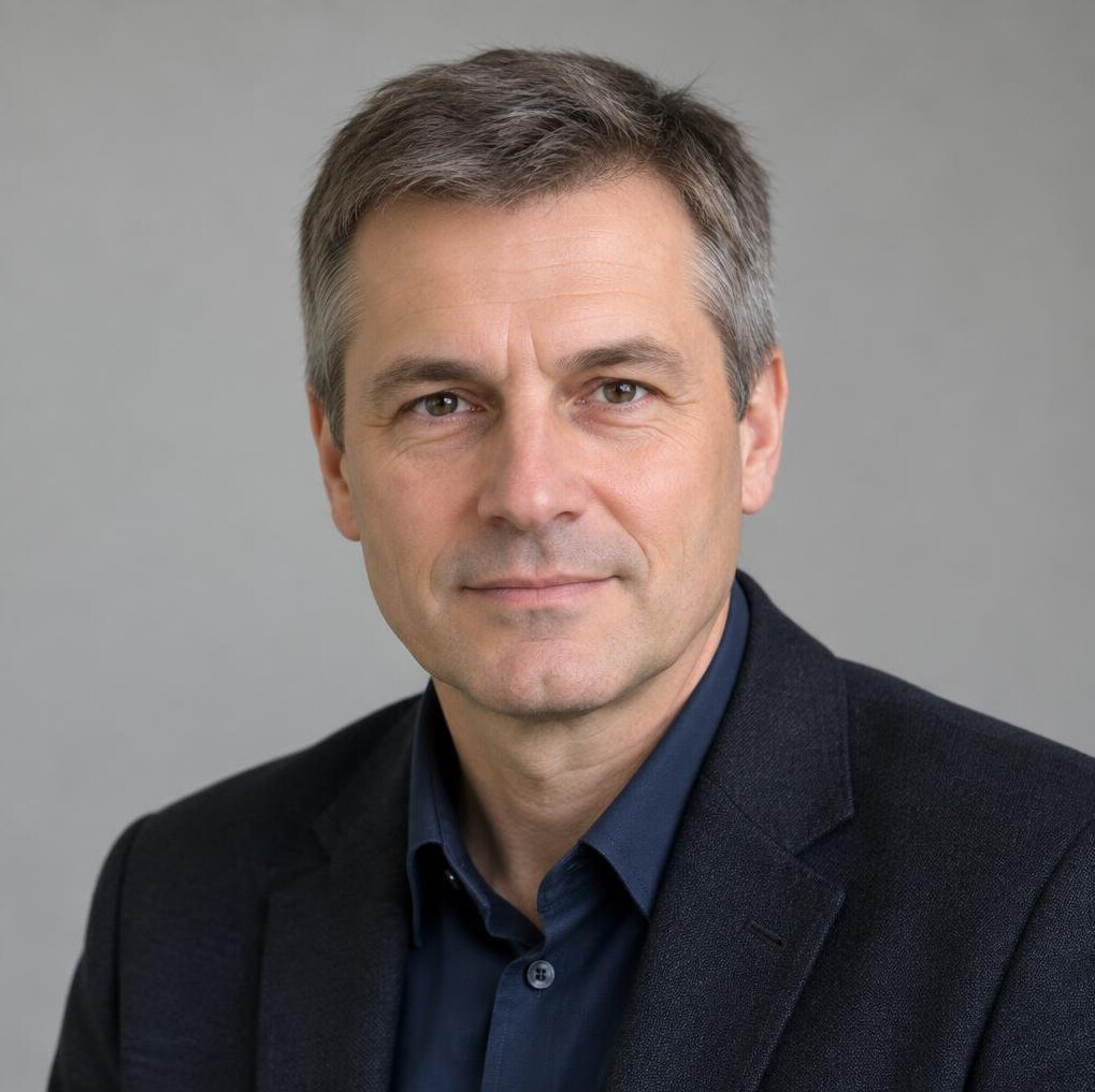 Portrait of a man in a dark jacket with a neutral background